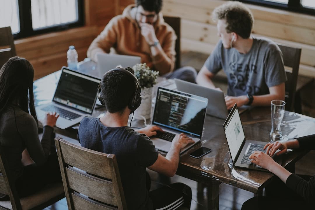Team collaborating on laptops in modern workspace