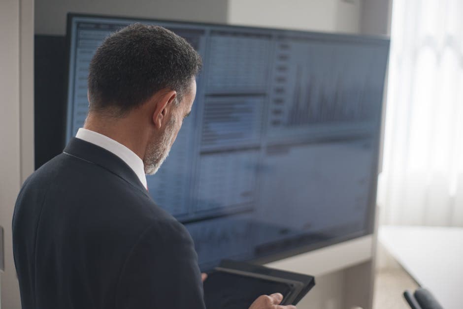 Professional analyzing stock markets on a digital tablet in a modern office setting.